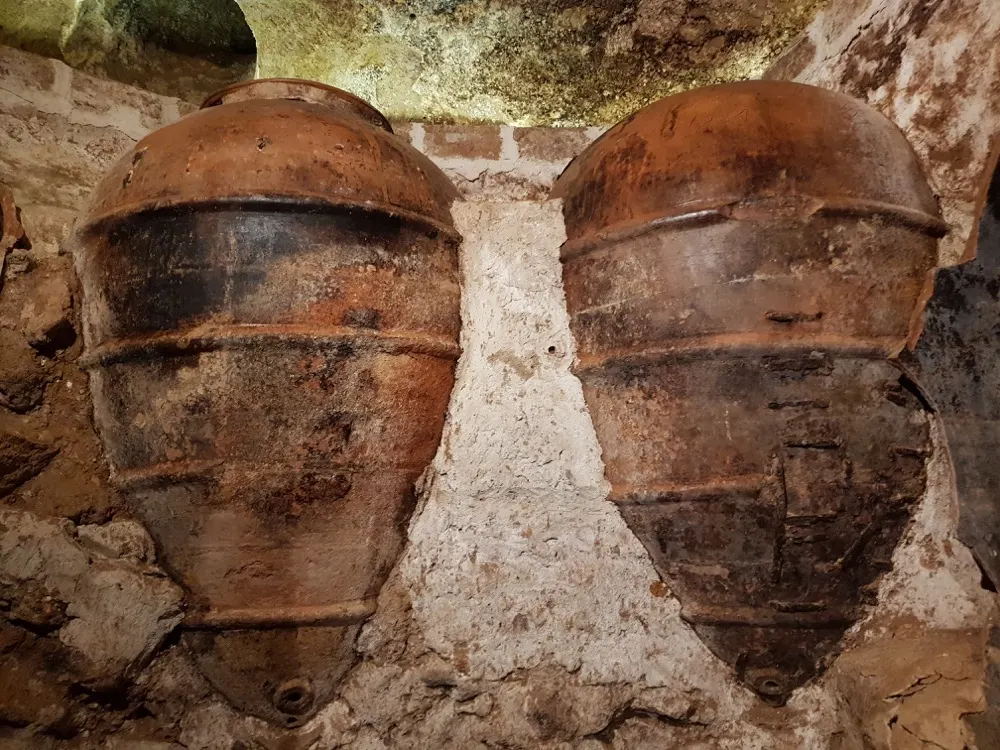 Tinajas de barro incrustadas en la roca de una bodega subterránea